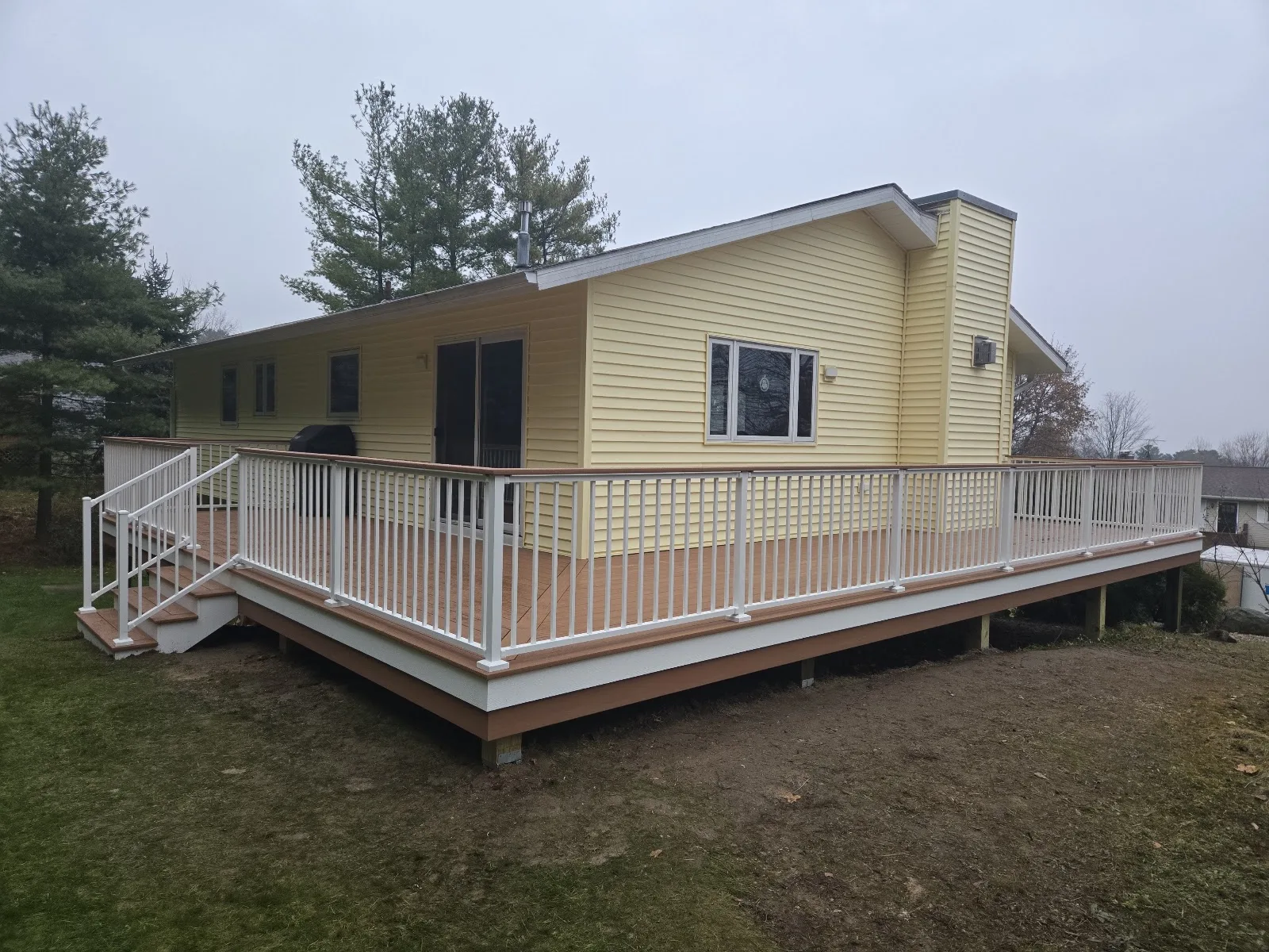 Composite deck with white railing in Forest Home Township MI