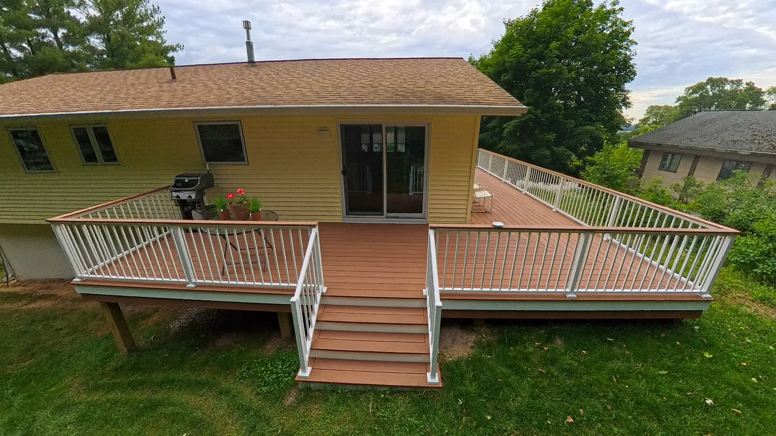Composite deck with white railings in Central Lake Township