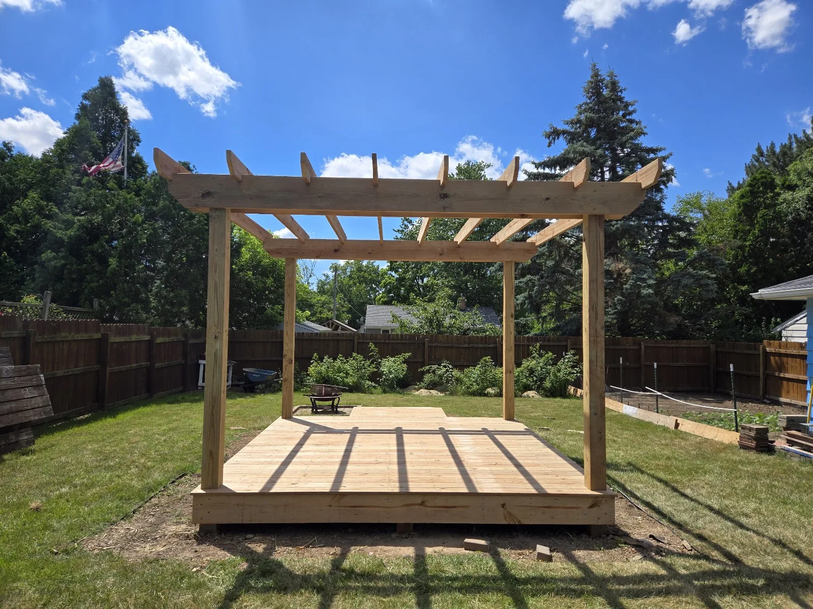 Custom wood deck with pergola in Central Lake Township
