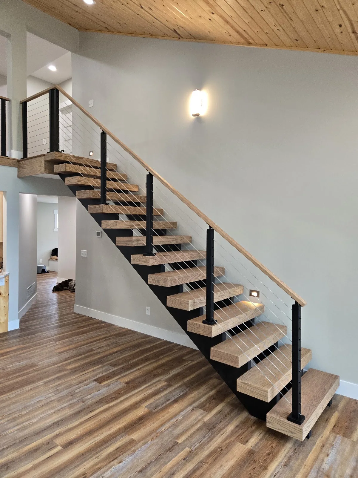 Wooden staircase with sleek cable railing in Banks Township MI